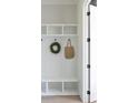 Mudroom with white shelving, hooks, and seating area at 158 Palisade Dr, Rydal, GA 30171