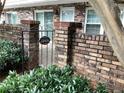 Close-up of a brick wall, wrought iron gate, and 'Come In We're Open' sign at 307 Adair St # 7-E, Decatur, GA 30030