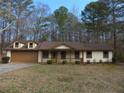 Charming single-story home featuring a well-manicured front lawn and an attached two car garage at 6832 Shangrila Way, Riverdale, GA 30296