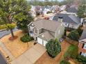 Aerial view of a beautiful green home featuring a two-car garage, a well-maintained lawn, and mature trees at 1548 Pinebreeze Dr, Marietta, GA 30062