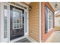 Welcoming front entrance with black door, sidelights, brick accents, and black shutters on the adjacent window at 1641 Hedington Ct, Lawrenceville, GA 30045