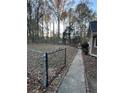 Large fenced backyard with tall trees, concrete walkway, and plenty of space for activities at 2720 Sandy Creek Cir, Loganville, GA 30052