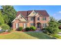 Attractive two-story brick home featuring a lush green lawn and established landscaping at 1755 Riverpark Dr, Dacula, GA 30019
