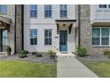 Charming townhome front door and landscape, with new construction and blue door at 4320 Sims Park Overlook, Suwanee, GA 30024