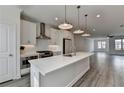 Modern, all-white kitchen featuring a kitchen island, stainless steel appliances, and recessed lighting at 4320 Sims Park Overlook, Suwanee, GA 30024