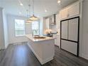 Well-lit kitchen with a large island, stainless steel appliances, and sleek white cabinets at 4320 Sims Park Overlook, Suwanee, GA 30024