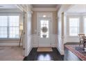 Welcoming foyer with dark hardwood floors, white wainscoting, and natural light at 5315 Hidden Valley Ln, Cumming, GA 30028