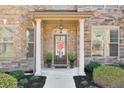 Charming front porch with stone accents, columns, and a decorative front door at 5315 Hidden Valley Ln, Cumming, GA 30028