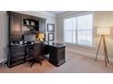 Comfortable office space with a large desk, built-in shelves, and a window at 5315 Hidden Valley Ln, Cumming, GA 30028