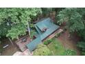 Aerial view of a charming home surrounded by lush trees, showcasing its metal roof and inviting wooden deck space at 6245 Bannister Rd, Cumming, GA 30028