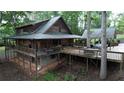 Back exterior view of a rustic home featuring a spacious porch, and a convenient carport, nestled among mature trees at 6245 Bannister Rd, Cumming, GA 30028