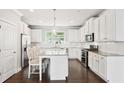 Bright kitchen featuring white cabinetry, granite counters, stainless appliances, and center island at 549 Henry Dr, Marietta, GA 30064