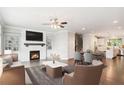 Open-concept living room with fireplace, built-in shelving, and hardwood floors flowing into the dining area and kitchen at 549 Henry Dr, Marietta, GA 30064