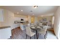 Open-concept dining area with a modern table and chairs, flowing into the kitchen and living space at 7706 Sudbury Cir, Covington, GA 30014