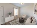 Cozy living room with a neutral color palette, stylish furniture, and natural light from the window at 7706 Sudbury Cir, Covington, GA 30014