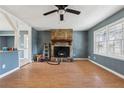 Living room with stone fireplace, ceiling fan, and open layout into the kitchen area at 401 Cabriolet Ct, Mcdonough, GA 30253