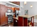 An open-concept kitchen boasts stainless steel appliances, wood cabinets, and stone countertops at 964 Dekalb Ne Ave # 112, Atlanta, GA 30307