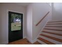 Bright entryway featuring hardwood floors, stairs with wooden railing, and a front door with a view at 553 Somersby Dr, Dallas, GA 30157