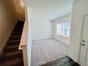 Inviting living room with plush carpeting and a staircase, perfect for relaxing and entertaining at 7714 Sudbury Cir, Covington, GA 30014