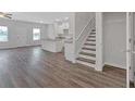 Bright, open-concept living area with wood floors, white kitchen, and staircase at 8656 Webb Rd, Riverdale, GA 30274