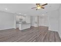 Open living space with modern lighting, wood floors, and a view into the kitchen area at 8656 Webb Rd, Riverdale, GA 30274