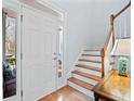 Bright foyer with hardwood floors, featuring a staircase and a glimpse of the porch through the sidelight window at 424 Melrose Ave, Decatur, GA 30030