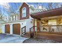 Two-story home with a two-car garage and covered porch with stone and wooden beam details at 10846 Sunfield Way, Hampton, GA 30228