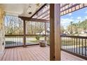 Spacious covered porch with wooden beams, stone accents, and iron railings overlooking the street at 10846 Sunfield Way, Hampton, GA 30228