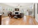 Bright living room with hardwood floors, a fireplace, a ceiling fan, and a comfortable leather couch at 2434 Soft Maple St, Atlanta, GA 30360