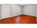 Bright bedroom featuring hardwood floors, a window, and a door leading outside at 5392 Fox Creek Ln, Norcross, GA 30071