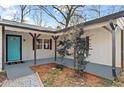 Inviting front porch with a vibrant teal door, neutral pavers and dark support beams at 2255 Hunt Rd, Douglasville, GA 30135