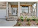 Close up of front porch, featuring brick columns, brick stairs, and a white front door at 3328 Sir Gregory Mnr, Lawrenceville, GA 30044