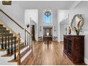 Spacious foyer features wood floors, staircase, soaring ceilings, chandelier, and elegant furnishings at 455 Emerald Lake Path, Sugar Hill, GA 30518