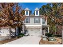 Charming townhome featuring a two-car garage, dormer windows, and inviting curb appeal at 3180 Spicy Cedar Ln, Lithonia, GA 30038