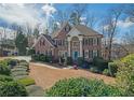 Beautiful brick home with meticulous landscaping, mature trees, and a welcoming front entrance at 6195 Mountainwell Dr, Roswell, GA 30075