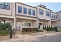 Inviting townhome exterior with gray siding, covered porch, manicured landscaping, and brick pathway at 671 Stickley Oak Way, Woodstock, GA 30189