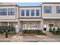 Charming townhome exterior featuring gray siding, well-maintained landscaping, and a covered front porch at 671 Stickley Oak Way, Woodstock, GA 30189