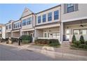 Serene townhome exterior featuring covered porches, lush greenery, and a well-maintained facade at 671 Stickley Oak Way, Woodstock, GA 30189