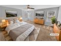 Staged main bedroom with neutral walls and carpet, complemented by natural light from the windows at 2473 Chauncey Sw Ln, Marietta, GA 30064