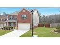 Brick two-story house with a two-car garage and green lawn in a quiet neighborhood at 3062 Hawthorn Farm Blvd, Loganville, GA 30052