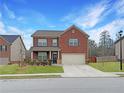 Inviting brick two-story home with a manicured lawn, featuring a welcoming entrance at 3062 Hawthorn Farm Blvd, Loganville, GA 30052