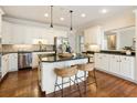 Well-lit kitchen with stainless steel appliances, white cabinets, hardwood floors, and an island with bar seating at 4155 Park Brook Dr, Alpharetta, GA 30022