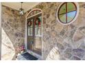 Elegant front entrance with stone detailing, round accent window, and festive holiday wreaths at 3529 S Sherwood Se Rd, Smyrna, GA 30082