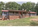 Attractive home featuring a brick foundation, gray siding, black shutters, and inviting front porch with decorative railings at 616 Rich Davis Rd, Hiram, GA 30141