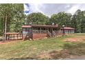 Charming home featuring a red metal roof, brick foundation, front porch, covered patio, and a front yard at 616 Rich Davis Rd, Hiram, GA 30141