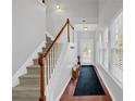 Bright entryway features a staircase with wood railing, hardwood floors, and a long runner leading to the front door at 2157 Capella Sw Cir, Atlanta, GA 30331