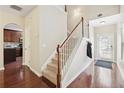 Inviting foyer with hardwood floors, staircase, and a view of the kitchen at 2157 Capella Sw Cir, Atlanta, GA 30331