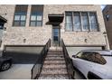Inviting home entrance featuring a brick staircase, modern door, and attached garage for convenient parking at 3208 Sonnet Se Walk, Atlanta, GA 30339
