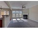 Sunlit living room featuring a cozy fireplace and large windows overlooking the backyard at 922 Gardenia Curv, Canton, GA 30114
