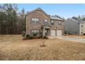 Two-story brick home featuring a spacious front yard with tasteful landscaping at 11930 Guelph Cir, Hampton, GA 30228